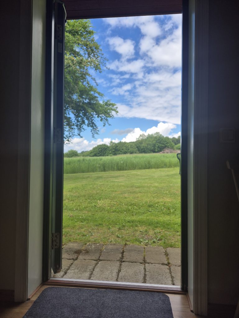 Ut genom dörren klarblå himmel